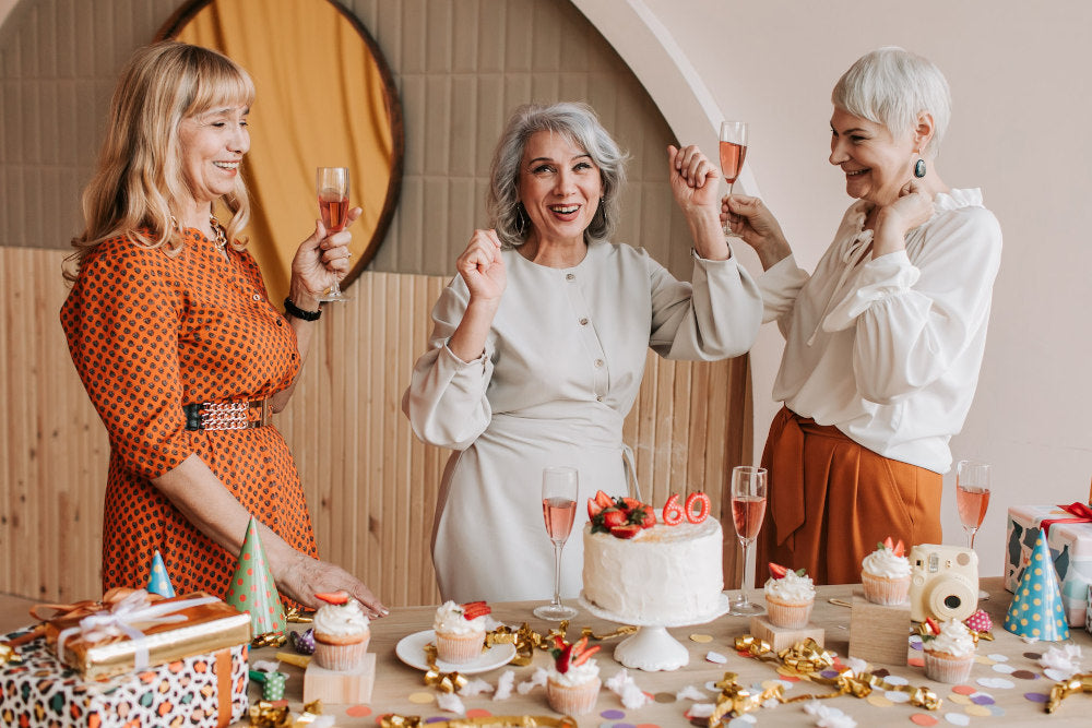 Three women over 60 celebrating in beautiful outfits