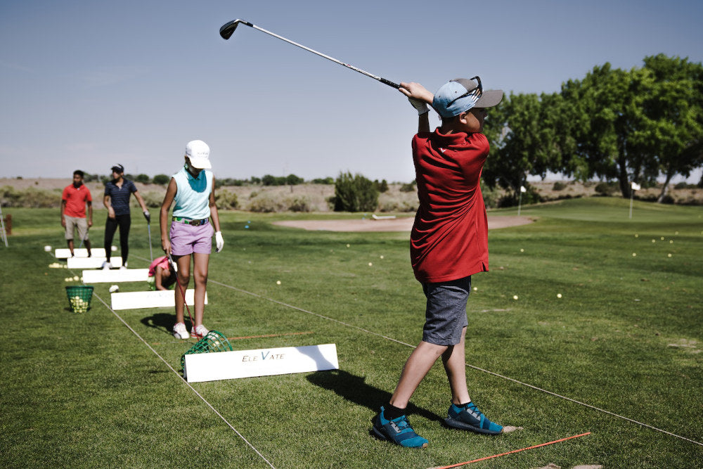 People on a golf driver range practicing golf